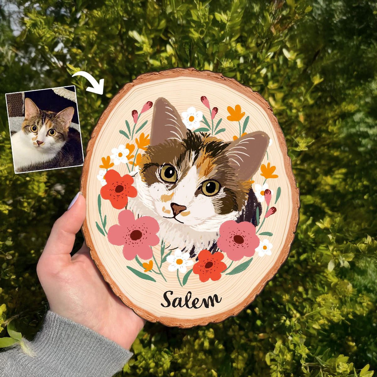May include: A wooden slice featuring a painted portrait of a cat with brown, white, and orange fur, surrounded by pink, orange, and white flowers. The cat's name, "Salem," is written in black script below the portrait.
