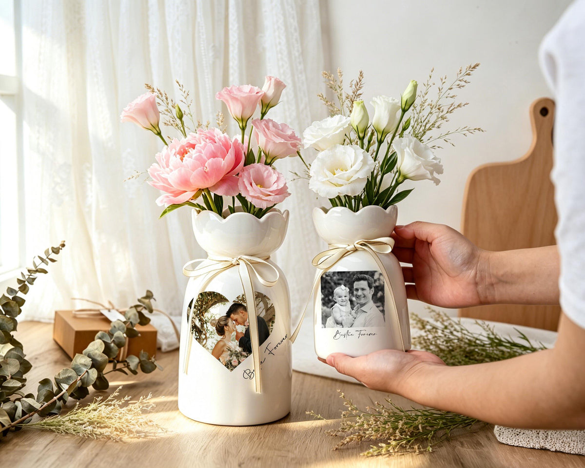 Two white ceramic vases with scalloped rims, each tied with a thin beige ribbon. The larger vase features a heart-shaped photo of a couple, while the smaller vase displays a rectangular photo of a family with the text "Bestie Forever."