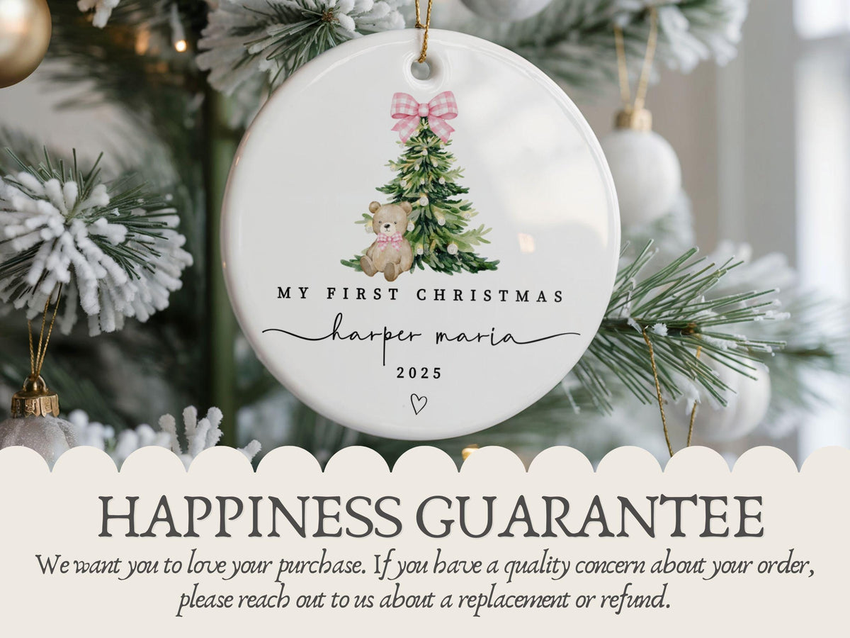 May include: A round white ceramic ornament featuring a watercolor illustration of a green Christmas tree with a pink gingham bow and a teddy bear. The text reads MY FIRST CHRISTMAS, harper maria, and 2025, with a small heart icon below.