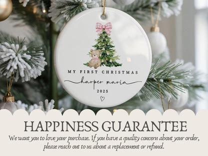 May include: A round white ceramic ornament featuring a watercolor illustration of a green Christmas tree with a pink gingham bow and a teddy bear. The text reads MY FIRST CHRISTMAS, harper maria, and 2025, with a small heart icon below.