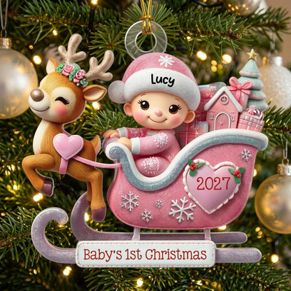 May include: A Christmas ornament featuring a reindeer with a floral crown pulling a pink sleigh. A baby in a pink hat labeled Lucy sits in the sleigh with gifts. A heart on the sleigh reads 2027, and the base reads Baby's 1st Christmas.