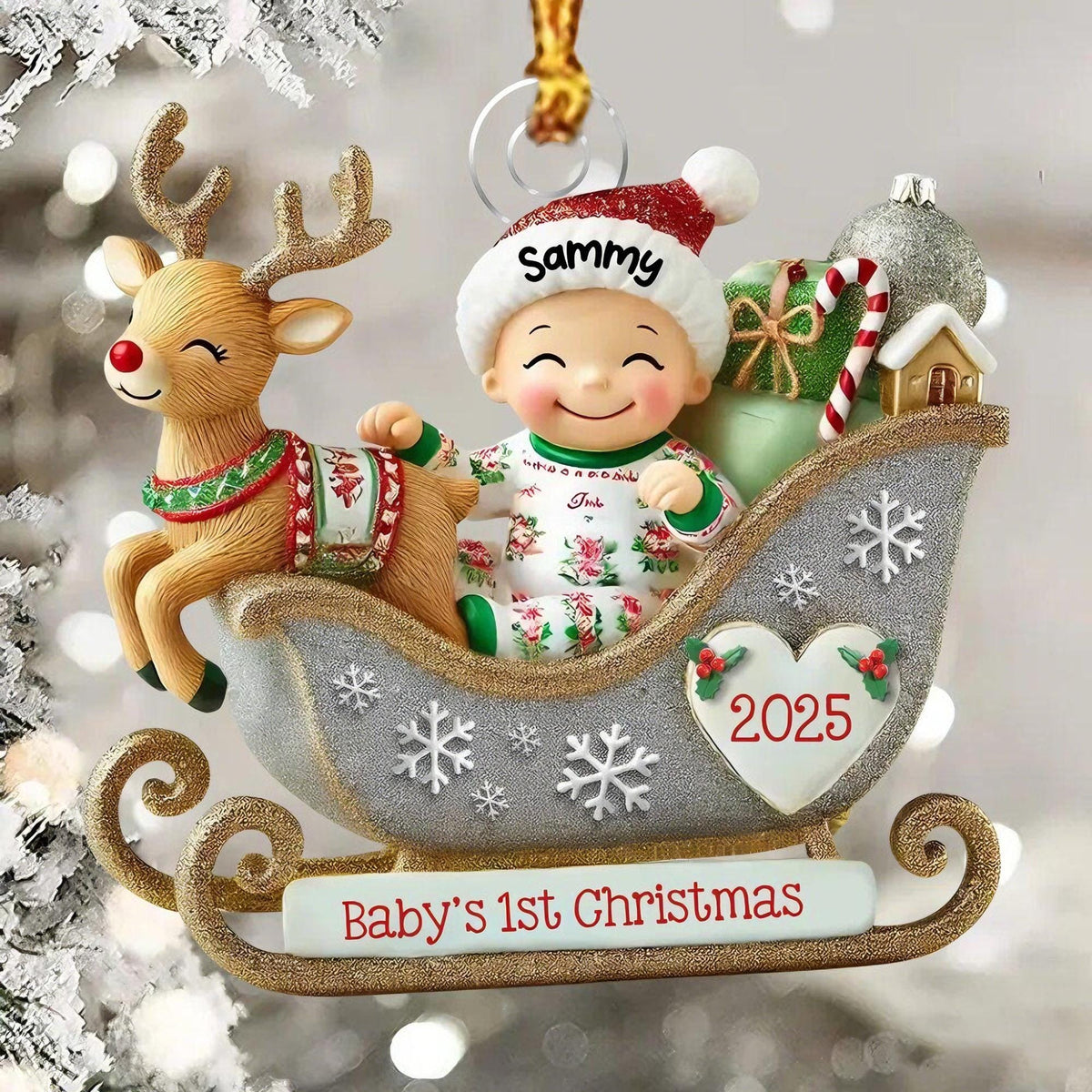 May include: A Christmas ornament featuring a reindeer and a baby in a silver glittery sleigh. The baby wears a red and white hat with the name Sammy. The sleigh has a heart with 2025 and a banner reading Baby's 1st Christmas.