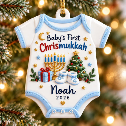May include: A white baby bodysuit-shaped Christmas ornament with light blue trim. It features the text "Baby's First Chrismukkah", a gold menorah, a decorated Christmas tree, a blue gift box, and baby booties. The name "Noah" and "2026" are printed.