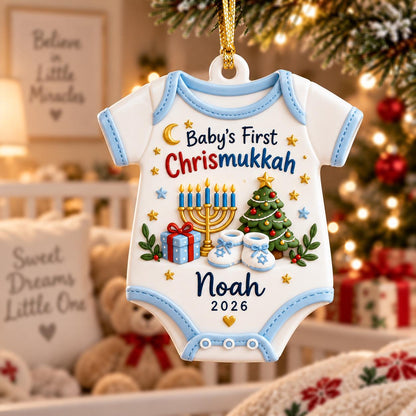 May include: A white baby onesie-shaped ornament with light blue trim, featuring the text Baby's First Chrismukkah, a gold menorah, a green Christmas tree, a blue gift box, white baby booties, and the name Noah with the year 2026 printed below.
