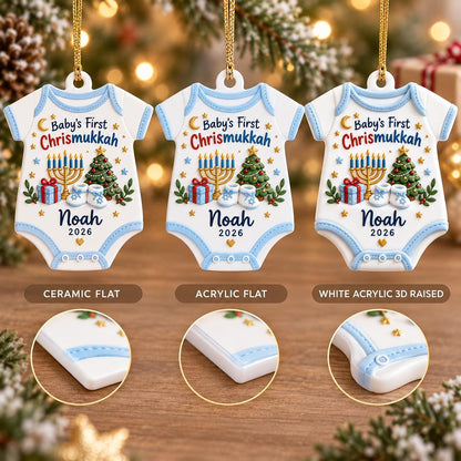 May include: Three white baby onesie-shaped ornaments with blue trim, featuring the text Baby's First Chrismukkah, Noah, and 2026. The design includes a menorah, a Christmas tree, gifts, and baby shoes. The image shows ceramic flat, acrylic flat, and white acrylic 3D raised versions.