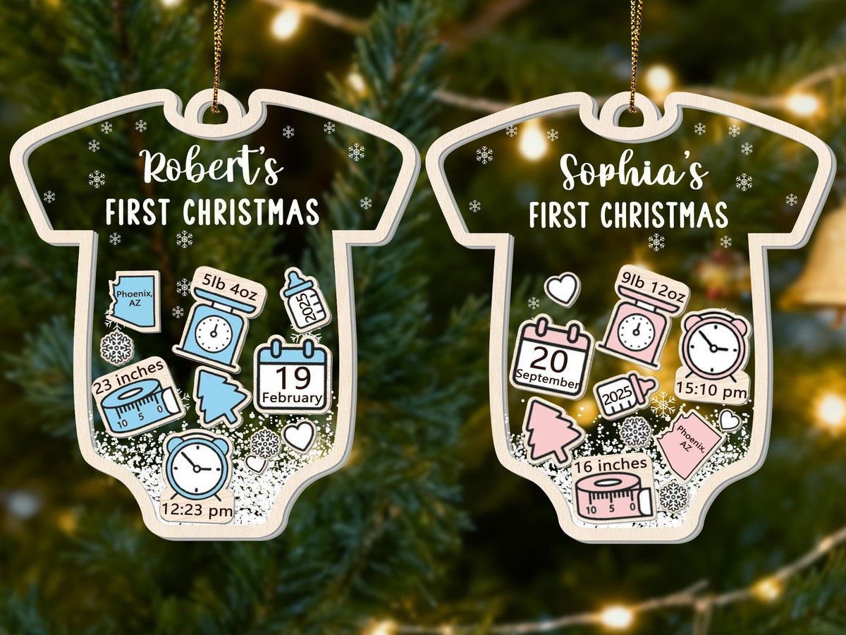 May include: Two personalized baby's first Christmas ornaments shaped like onesies. One features "Robert's FIRST CHRISTMAS" with birth details: 5lb 4oz, 23 inches, and February 19. The other says "Sophia's FIRST CHRISTMAS" with 9lb 12oz, 16 inches, and September 20.