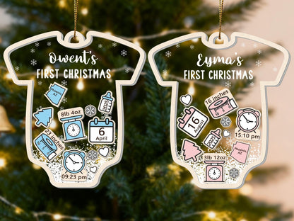 May include: Two baby onesie-shaped Christmas ornaments. One reads "Dwent's FIRST CHRISTMAS" with birth details: 8lb 4oz, 23 inches, April 6, and 9:23 pm. The other reads "Eyma's FIRST CHRISTMAS" with birth details: 3lb 12oz, 16 inches, August 16, and 3:10 pm.