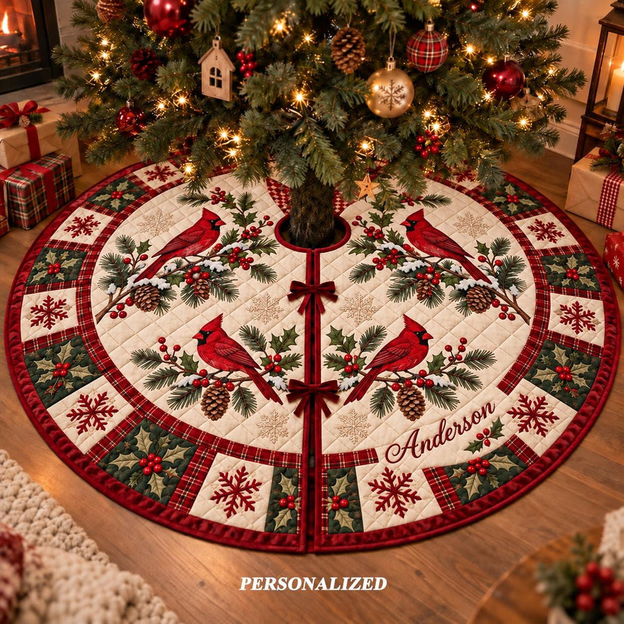 May include: A round, quilted Christmas tree skirt featuring a cream-colored center with four red cardinal birds perched on pine branches with pinecones. The border displays a pattern of red and green holly leaves, berries, and snowflakes, with the name Anderson embroidered in script.