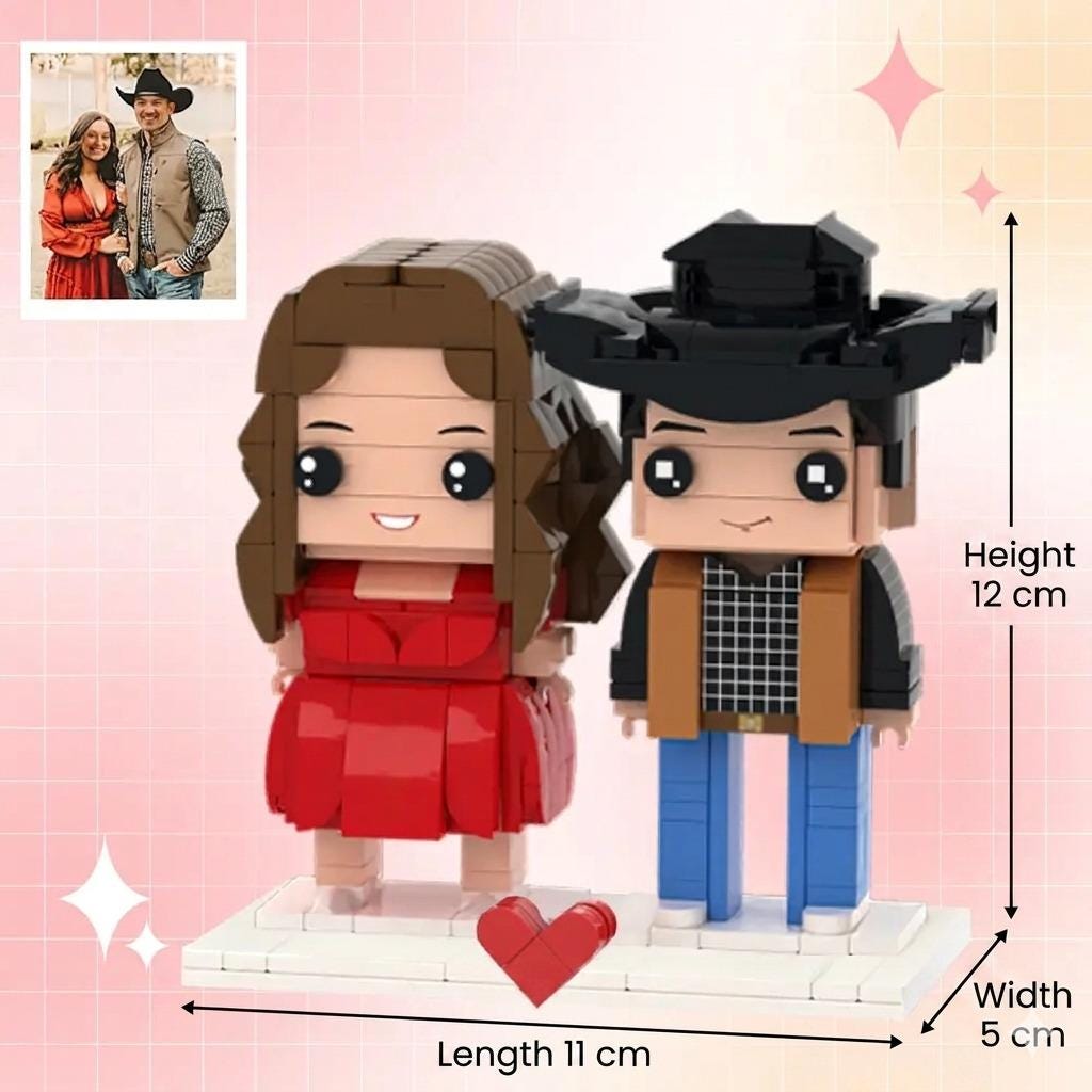 A custom brick-built figurine set featuring two characters on a white base with a red heart. The female figure has brown hair and a red dress. The male figure wears a black cowboy hat, tan vest, and blue pants. Dimensions are 12 cm high, 11 cm long, 5 cm wide.