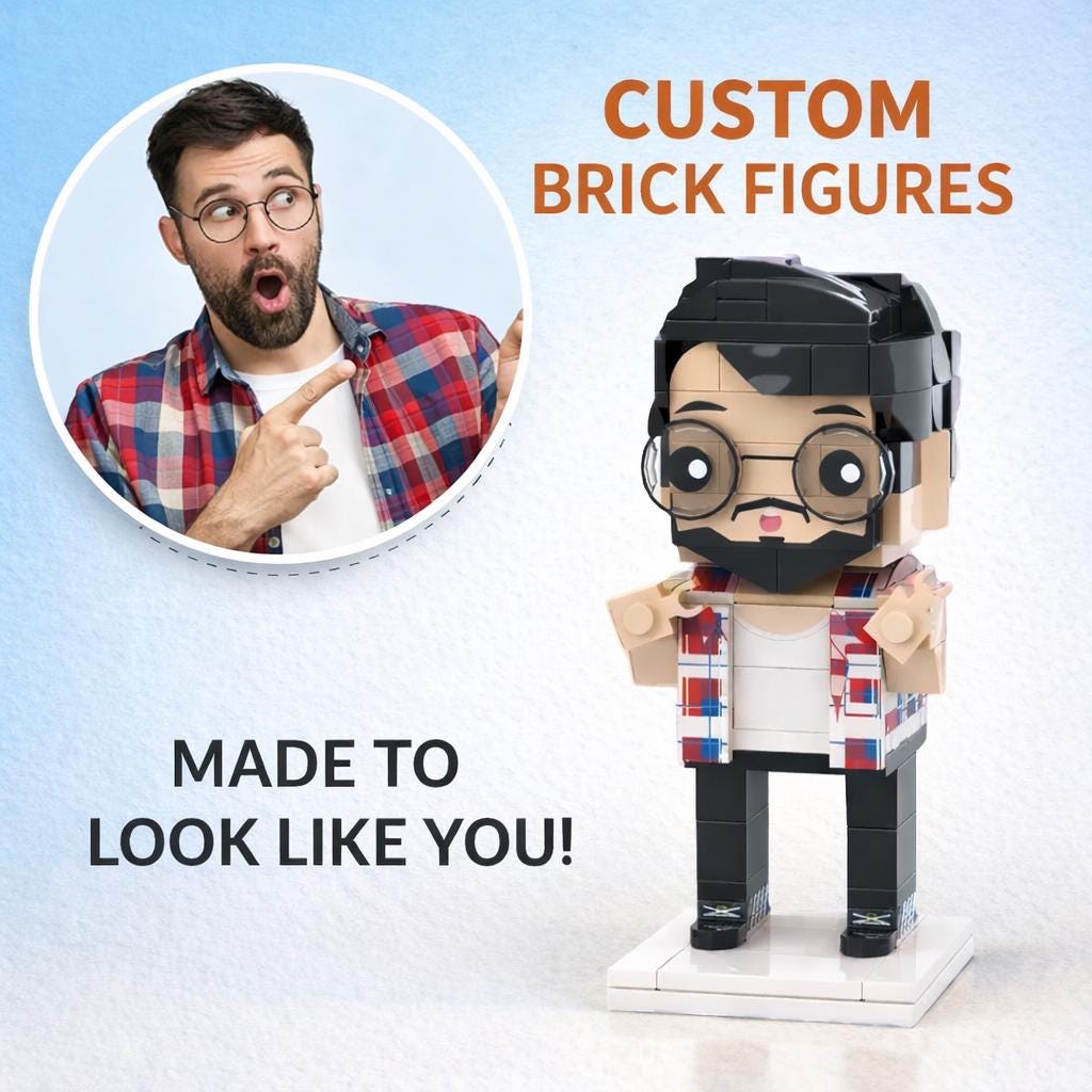 A custom brick figure constructed from interlocking plastic blocks, featuring a bearded character with black hair and round glasses, wearing a white shirt and a red, white, and blue plaid overshirt, standing on a white square base.