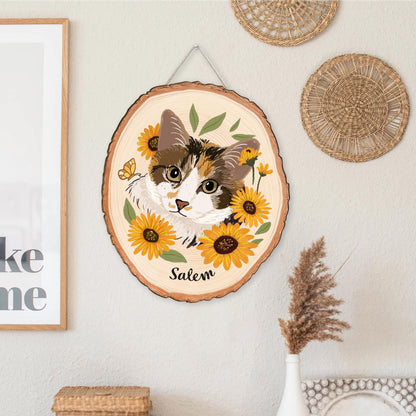 May include: A wooden slice wall hanging featuring a cat portrait surrounded by sunflowers and greenery. The cat has brown, white, and orange fur. The name "Salem" is written below the cat. A butterfly is also included in the design.