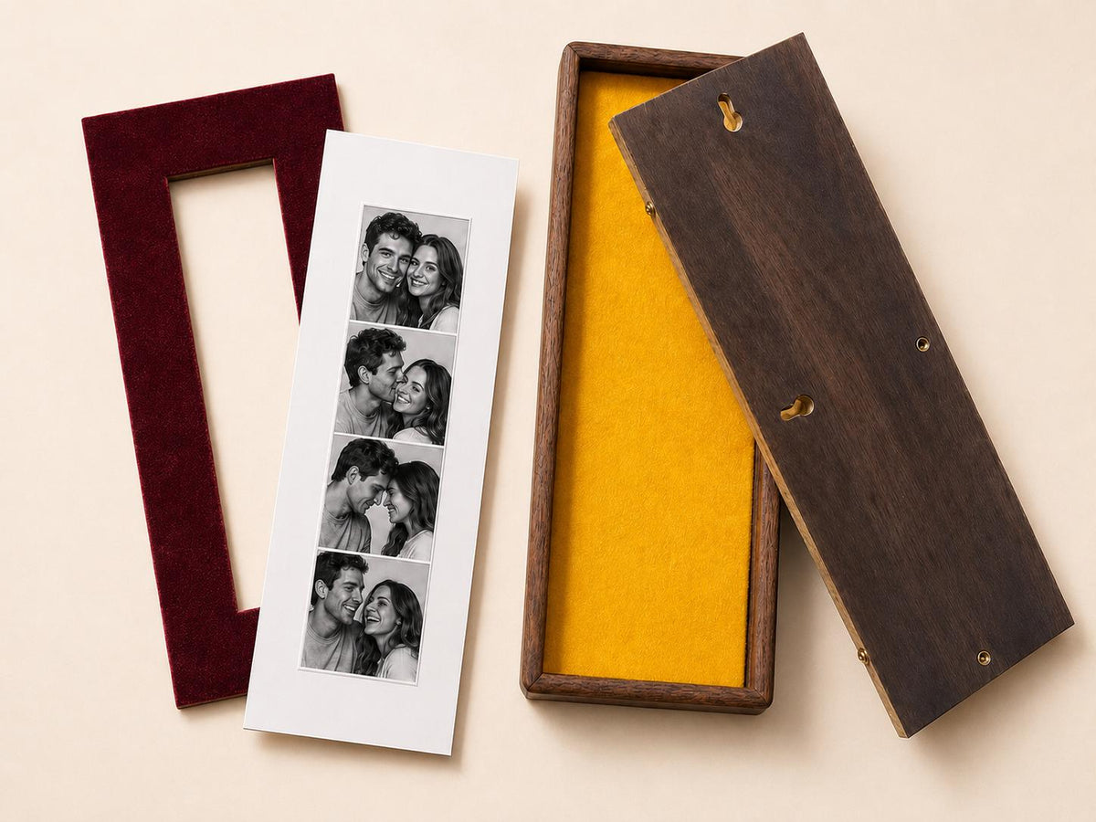 A rectangular dark wood display box with a bright yellow interior lining, a matching dark wood lid with two keyhole slots, and a separate maroon velvet mat frame containing a vertical photo strip of a couple in black and white.