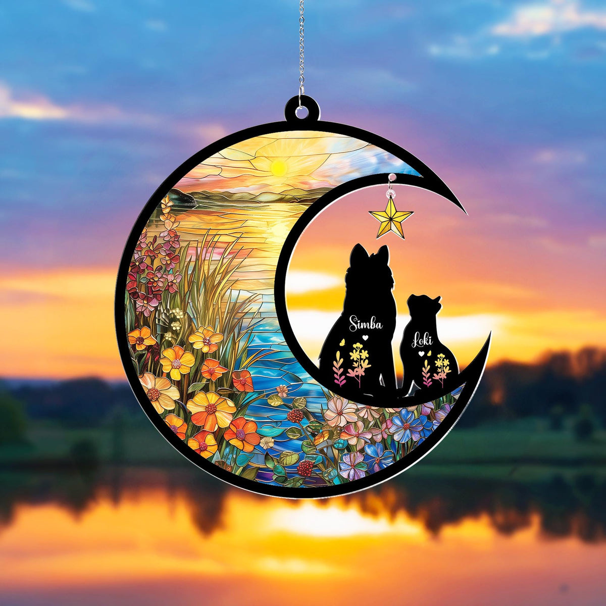 May include: A decorative crescent moon ornament featuring silhouettes of two dogs, Simba and Loki, with floral accents. The ornament is set against a stained-glass style sunset scene with a hanging star.
