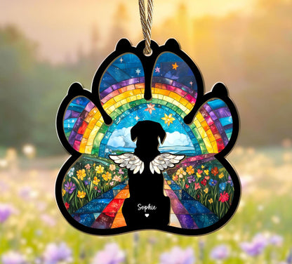 May include: A rainbow paw print ornament with a silhouette of a dog with wings and the name "Sophie" in the center. The ornament is made of glass and has a colorful mosaic design.