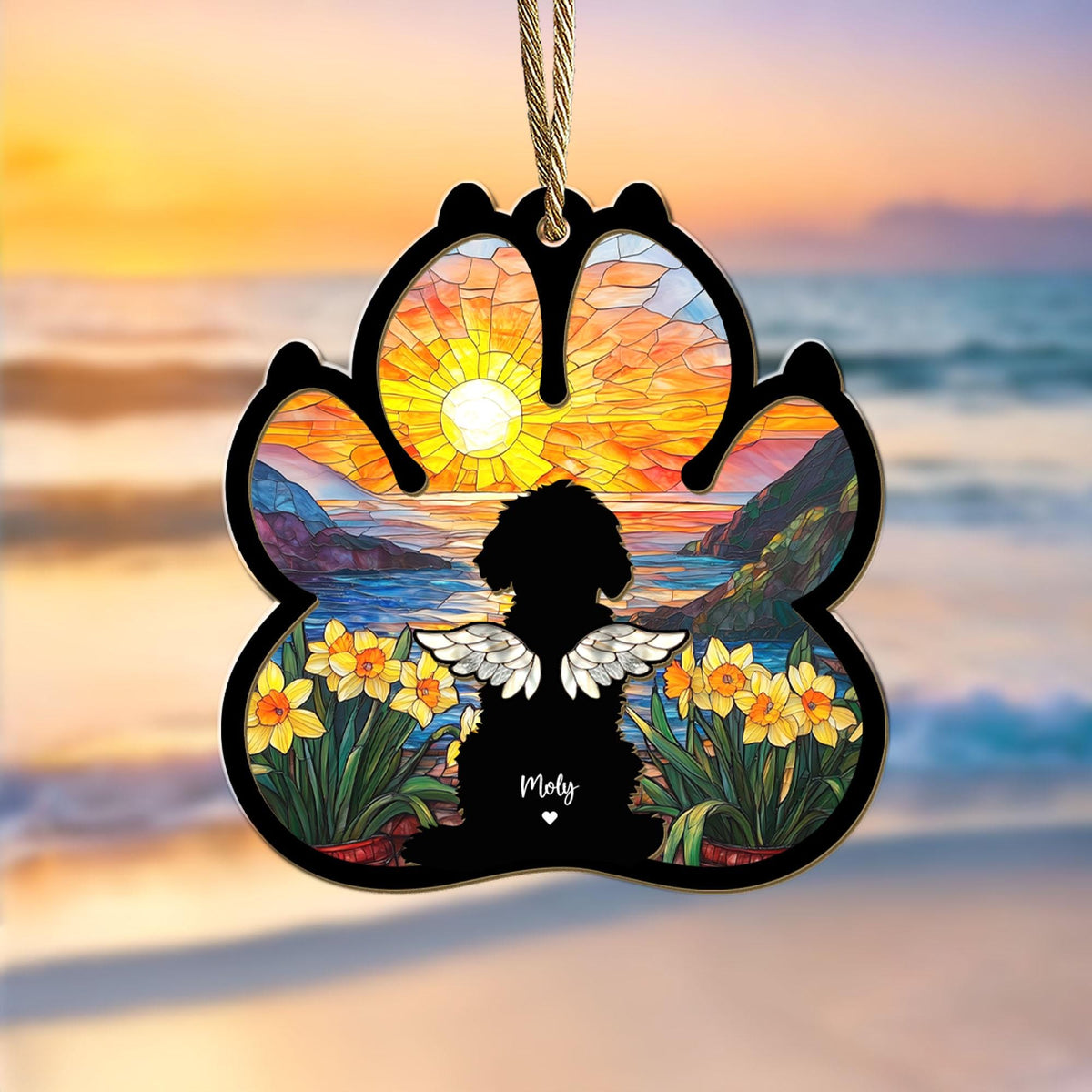 May include: A stained glass paw print ornament with a silhouette of a dog with angel wings, a sunset scene, and daffodils. The ornament is personalized with the name "Molly".