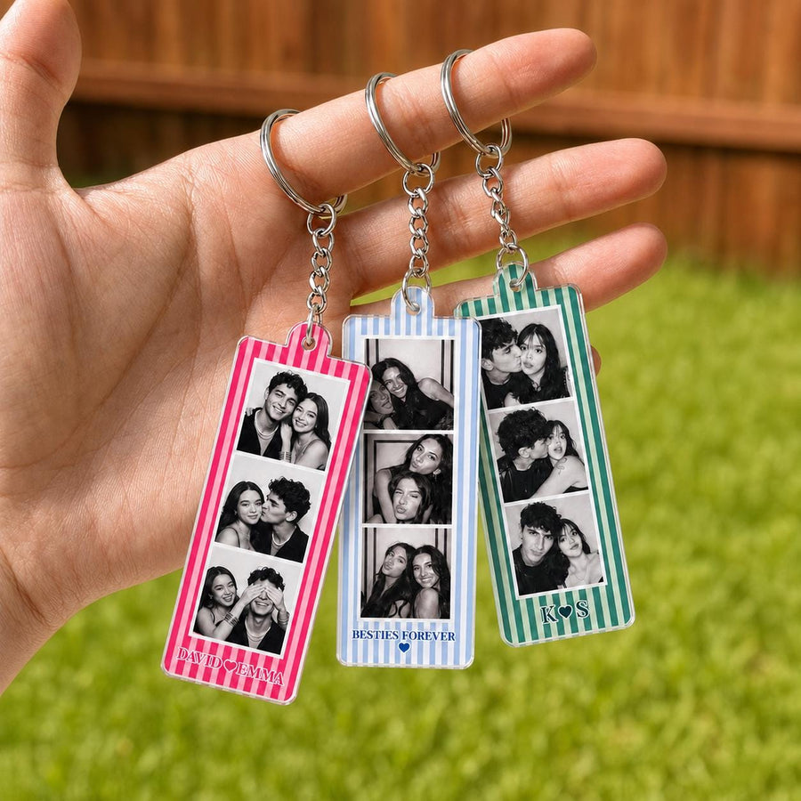 Three rectangular acrylic keychains with metal rings and chains. Each features vertical stripes in pink, light blue, or green, and contains three black and white photo strips. Text includes names David and Emma, Besties Forever, and K S.