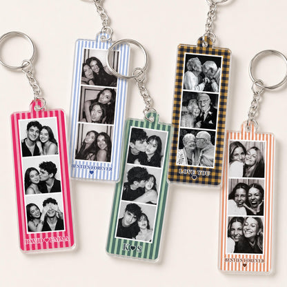 Five rectangular acrylic keychains with metal rings, each featuring a vertical strip of three black and white photos. The keychains have colorful striped borders in pink, blue, green, yellow plaid, and orange, with printed text and heart icons.