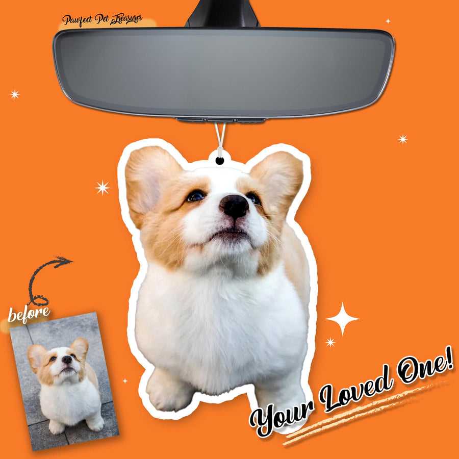 A car air freshener featuring a corgi dog with white, tan, and brown fur. The air freshener is hanging from a car's rearview mirror. The words "Your Loved One!" are written on the bottom right.