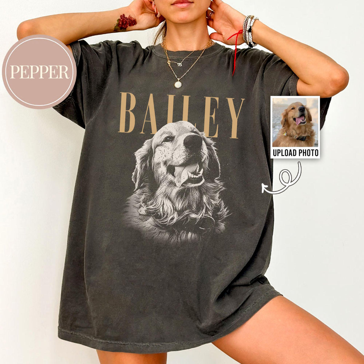 Dark gray t-shirt featuring a sepia-toned image of a Golden Retriever with the name "BAILEY" above it in tan letters. A small photo of a dog is on the right with the text "UPLOAD PHOTO".