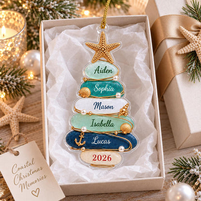 A clear, tree-shaped Christmas ornament featuring stacked, smooth, oval-shaped segments in shades of light green, teal, white, and dark blue. The ornament is decorated with a gold starfish, small seashells, pearls, and an anchor charm.