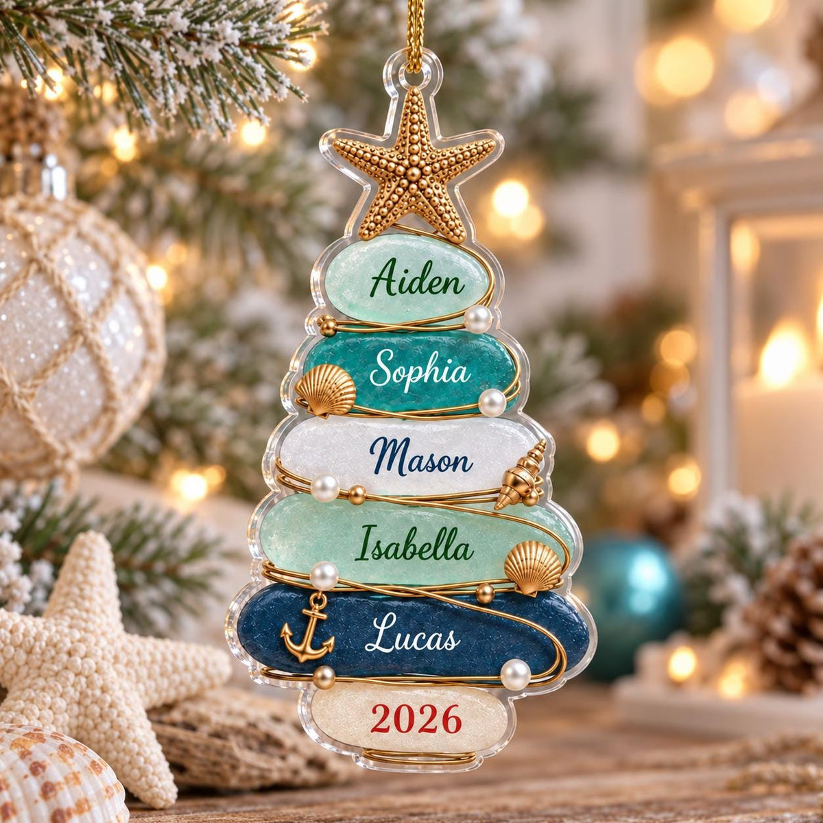 A clear acrylic Christmas tree ornament featuring a gold starfish topper and six horizontal layers in shades of blue, green, and white. Each layer displays a name: Aiden, Sophia, Mason, Isabella, Lucas, and the year 2026 in red.