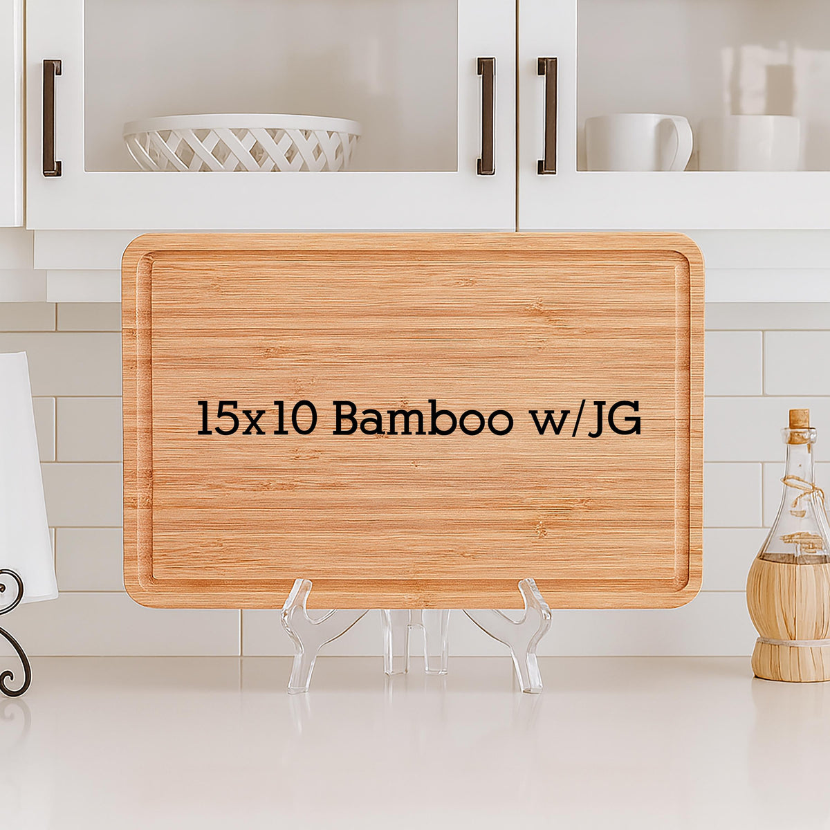 A rectangular bamboo cutting board, measuring 15 x 10 inches, with a juice groove. The board is displayed on a clear plastic stand. The text "15x10 Bamboo w/JG" is printed on the board.