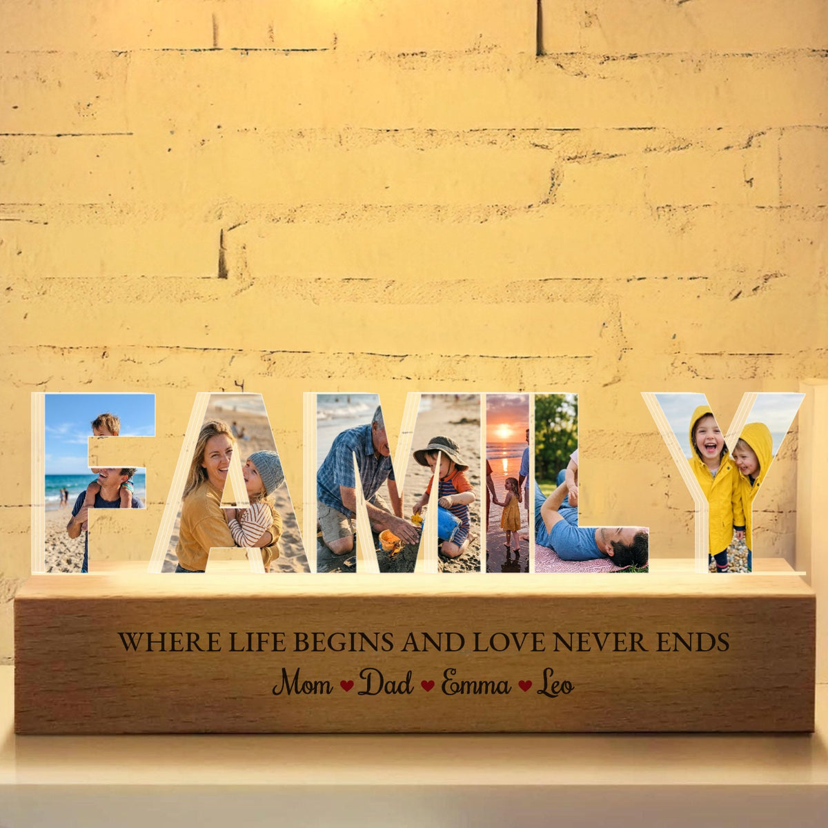 Custom word photo collage night light spelling FAMILY, a different family photo in each acrylic letter, on a lit wooden base printed with Where life begins and love never ends and the names Mom, Dad, Emma, Leo