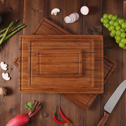 Three wooden cutting boards of different sizes, nested together. The boards are made of light brown bamboo and have a smooth, polished finish. The boards are ideal for preparing food and can be used for a variety of tasks, such as chopping vegetables, slicing meat, and serving food.