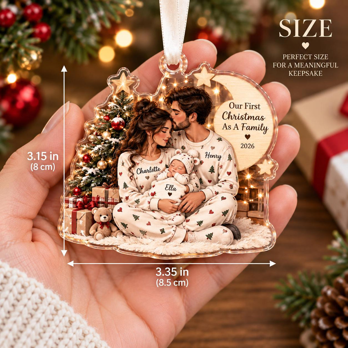 May include: A clear acrylic Christmas ornament measuring 3.15 inches by 3.35 inches, featuring a printed illustration of a family in pajamas with a baby, a Christmas tree, and the text Our First Christmas As A Family 2026 with names.