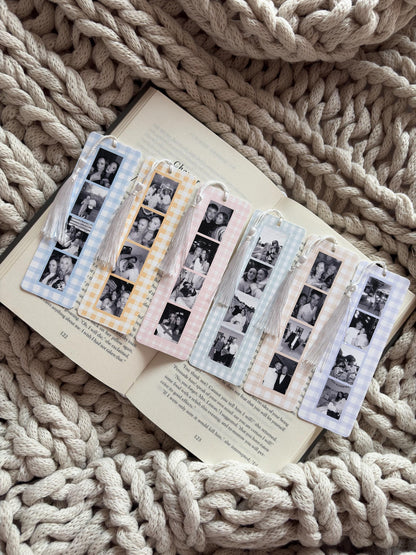 Six rectangular bookmarks with gingham patterns in blue, yellow, pink, and purple. Each bookmark features a vertical strip of black and white photo booth-style images and a white tassel attached to the top with a small white bead.