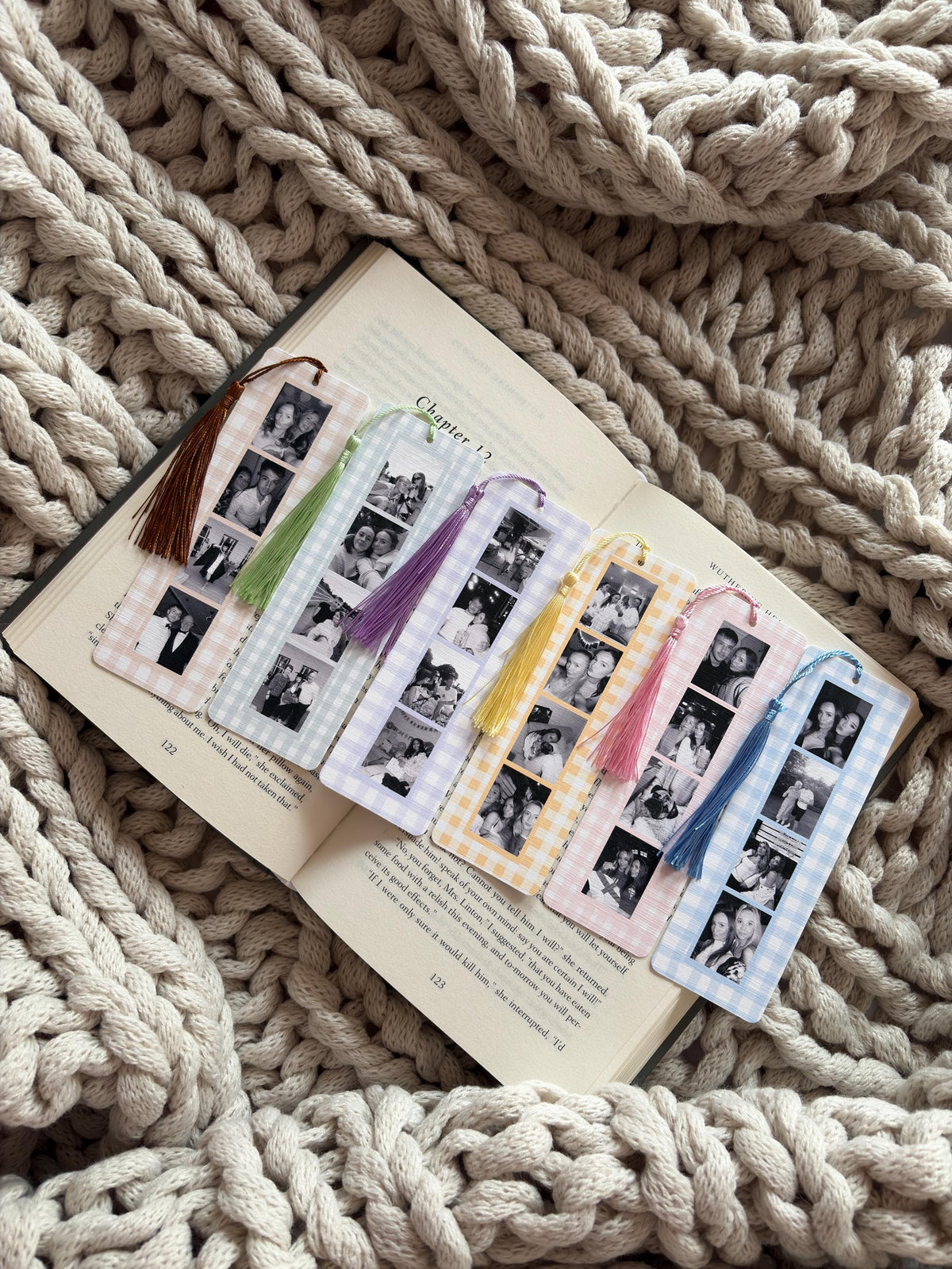 Six rectangular bookmarks with a gingham check border in various pastel colors, each featuring a vertical strip of black and white photo booth images and a matching silk tassel attached to the top hole of each bookmark.