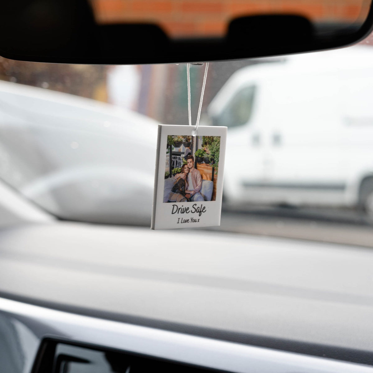 White car air freshener with a photo of a couple and the text "Drive Safe I Love You" printed on it.