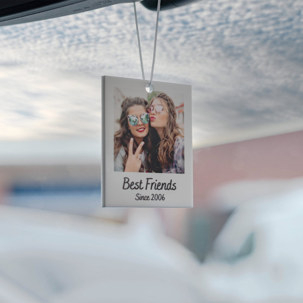 White car air freshener with a photo of two friends wearing sunglasses and the text "Best Friends Since 2006".