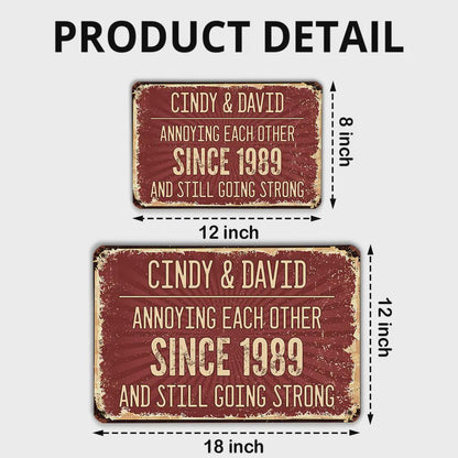Two rectangular metal signs with distressed edges. The signs are red with white text that reads "CINDY & DAVID ANNOYING EACH OTHER SINCE 1989 AND STILL GOING STRONG." The larger sign is 18 inches long and 12 inches high.
