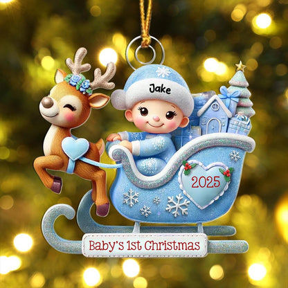 May include: A Christmas ornament featuring a brown reindeer with a blue floral crown pulling a light blue glittery sleigh. Inside the sleigh sits a baby wearing a blue hat labeled Jake. The sleigh displays the year 2025 and the text Baby's 1st Christmas.