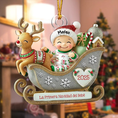 May include: A Christmas ornament featuring a reindeer and a baby in a silver glittery sleigh. The baby wears a red hat with the name Mateo and a patterned outfit. The sleigh displays the text 2025, La Primera Navidad del Beb&eacute;, and snowflakes.