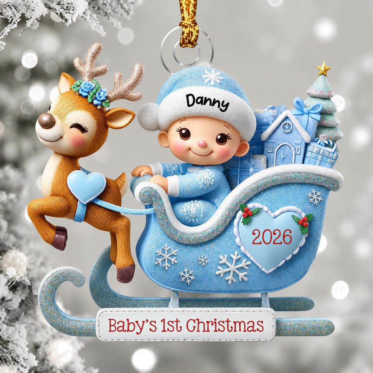 May include: A Christmas ornament featuring a brown reindeer with blue flowers on its antlers pulling a light blue sleigh. A baby in a blue hat with the name Danny sits in the sleigh, which is decorated with a heart labeled 2026 and the text Baby's 1st Christmas.