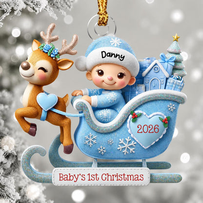 May include: A Christmas ornament featuring a brown reindeer with blue flowers on its antlers pulling a light blue sleigh. A baby in a blue hat with the name Danny sits in the sleigh, which is decorated with a heart labeled 2026 and the text Baby's 1st Christmas.