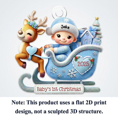 May include: A flat 2D printed ornament featuring a baby in a blue hat labeled Jake sitting in a blue sleigh with a reindeer. The sleigh displays the year 2025 on a heart and the text Baby's 1st Christmas on a banner. The design includes gifts.