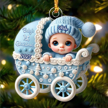 May include: A light blue baby carriage ornament featuring a baby wearing a matching blue knit hat with the name Mike printed on it. The carriage is decorated with white trim and the text Baby's 1st Christmas 2025. It hangs from a gold cord.