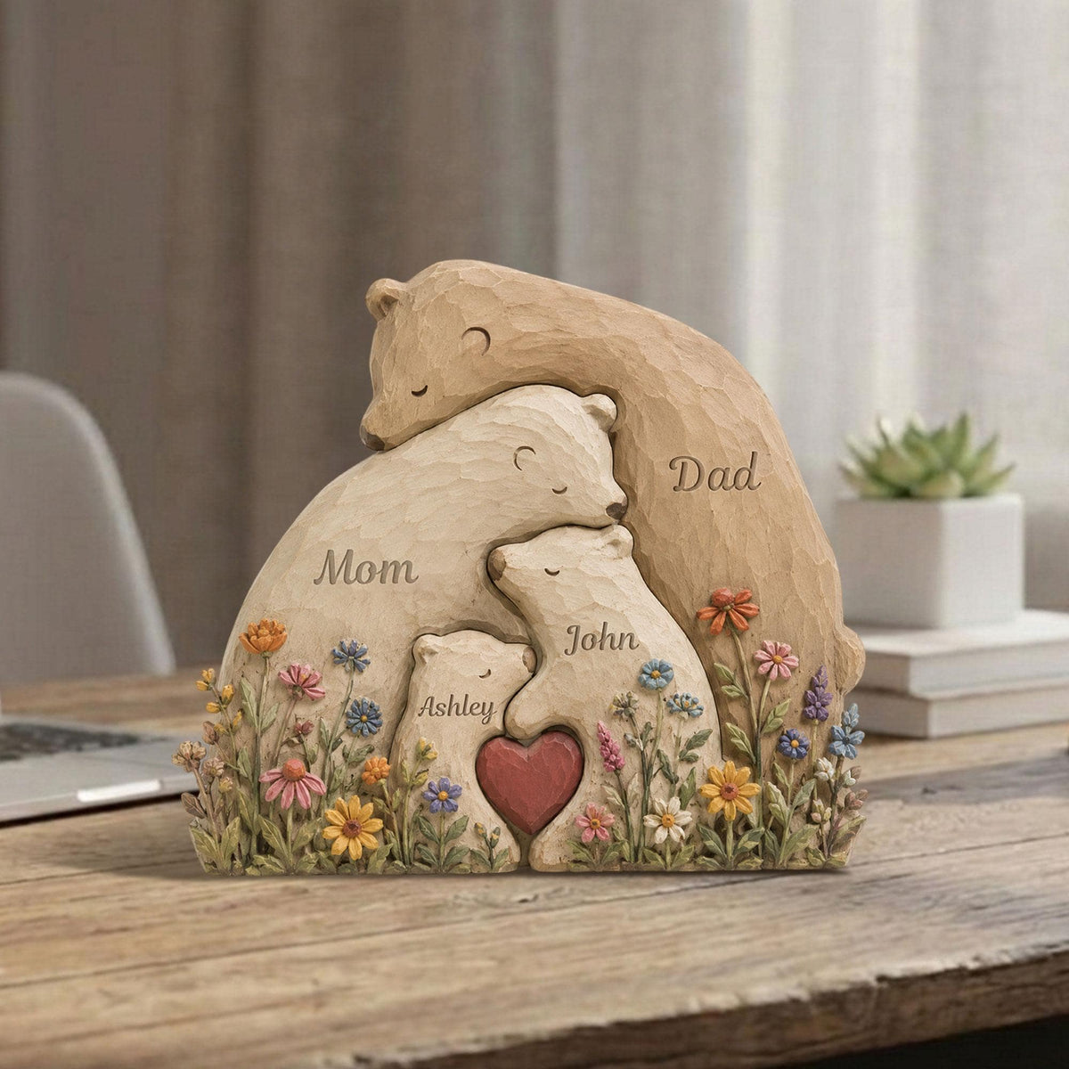 May include: A carved bear family sculpture with the words "Mom," "Dad," "Ashley," and "John." The sculpture features a heart and colorful flowers. The bears are in shades of beige and brown.