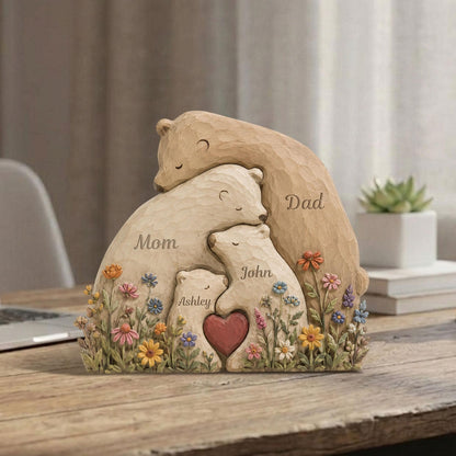 May include: A carved bear family sculpture with the words "Mom," "Dad," "Ashley," and "John." The sculpture features a heart and colorful flowers. The bears are in shades of beige and brown.