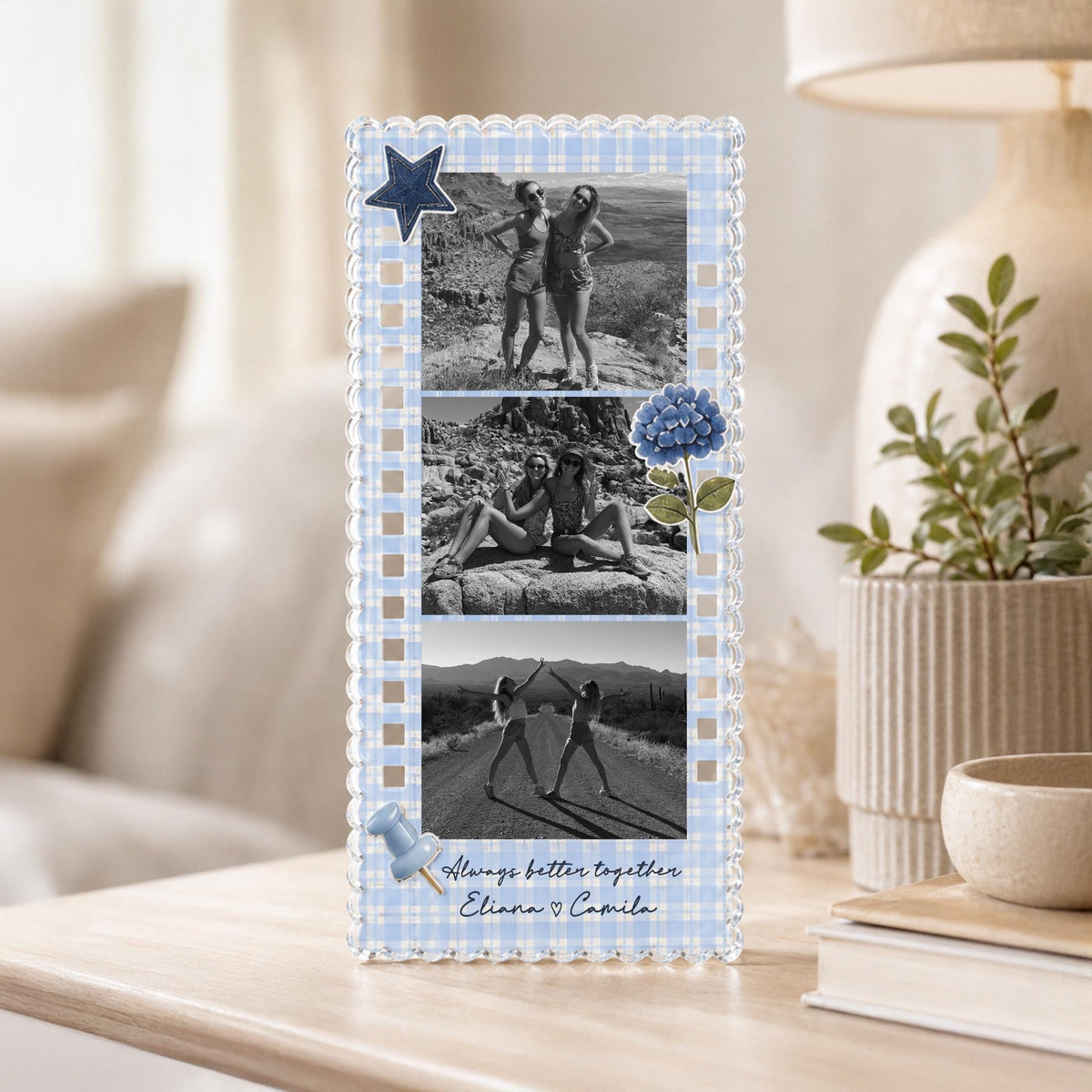 May include: A rectangular acrylic photo frame with a light blue and white gingham border. It displays three black and white photos of two people, a dark blue star, a blue hydrangea flower, a blue pushpin, and the text Always better together Eliana ♡ Camila.