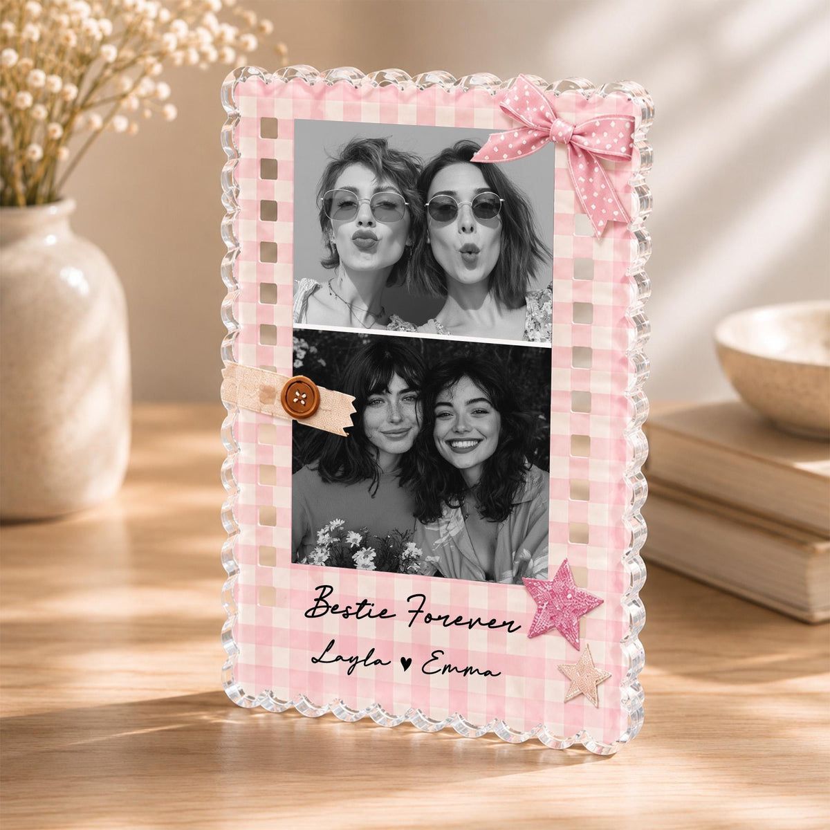 May include: A rectangular acrylic photo frame with a pink and white gingham border, featuring two black and white photos of two people. The frame is decorated with a pink polka dot bow, a brown button, and two star-shaped accents with the text Bestie Forever Layla &hearts; Emma.