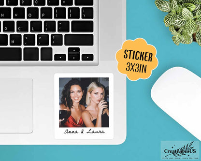 A square sticker featuring a photograph of two individuals, one with dark hair in a red top and one with blonde hair in a black top, with the text Anna & Laura printed below the image. The sticker measures 3x3 inches in size.