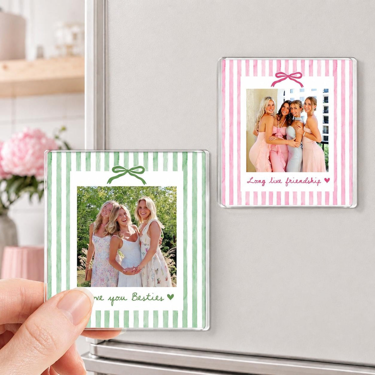 Two square photo magnets featuring vertical stripes and a bow graphic. One magnet has green stripes with the text "love you Besties" and a heart. The other has pink stripes with the text "Long live friendship" and a heart.