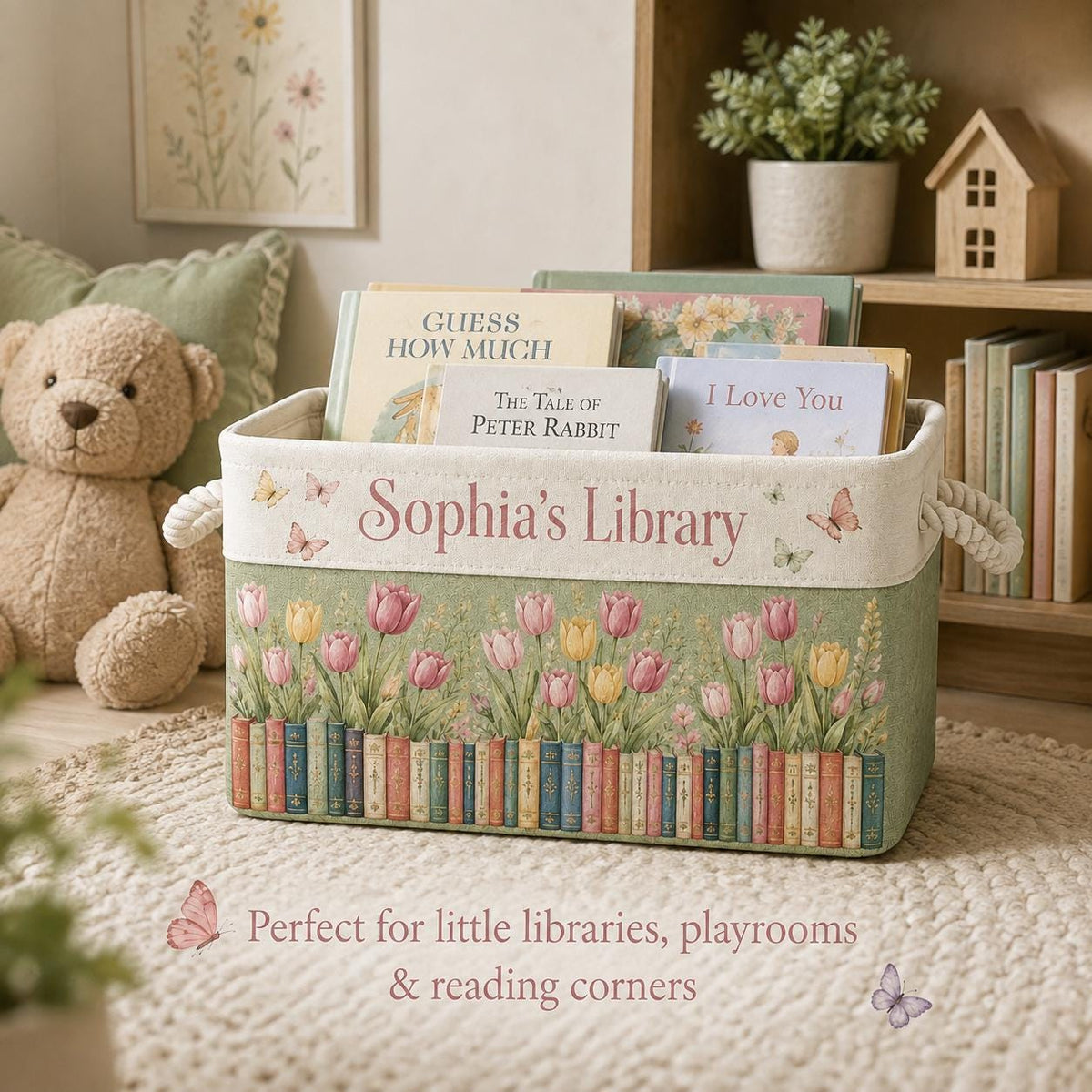 May include: A rectangular fabric storage bin with rope handles, featuring a sage green base with a printed row of colorful books and pink and yellow tulips. The top cream-colored band displays the text Sophia's Library with butterfly accents.