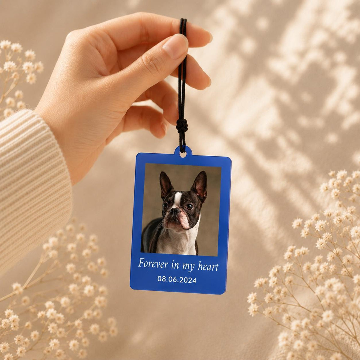 A rectangular blue hanging ornament featuring a photograph of a Boston Terrier dog. The text "Forever in my heart" and the date "08.06.2024" are printed in white below the image. The ornament hangs from a black cord.