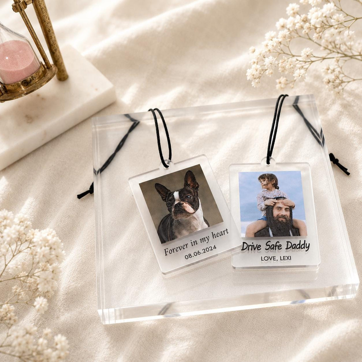 Two rectangular clear acrylic ornaments with black hanging cords. One features a French Bulldog photo with the text "Forever in my heart 08.06.2024". The other shows a person with a child and the text "Drive Safe Daddy LOVE, LEXI".