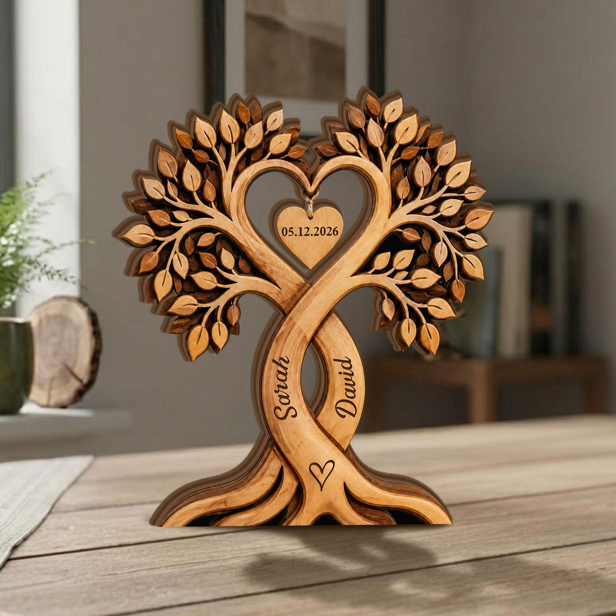 May include: A wooden tree sculpture with intertwined trunks, forming a heart shape. The sculpture features intricate leaf details and the names "Sarah" and "David" carved into the trunks. A heart-shaped tag displays the date "05.12.2026".